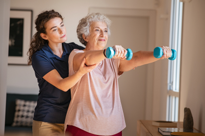 elderly patient using dumbbells with outstretched arms